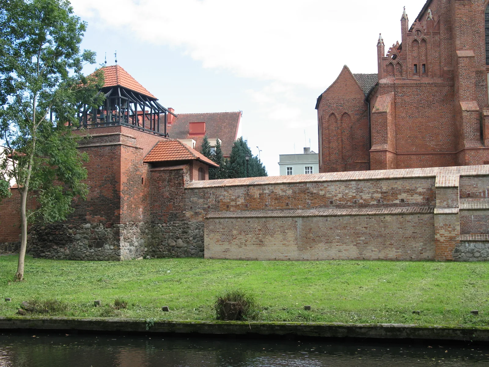 Fragment średniowiecznych murów obronnych w Starogardzie Gdańskim. Widok od strony rzeki Wierzycy. Po prawej lewa nawa fary p.w św. Mateusza.