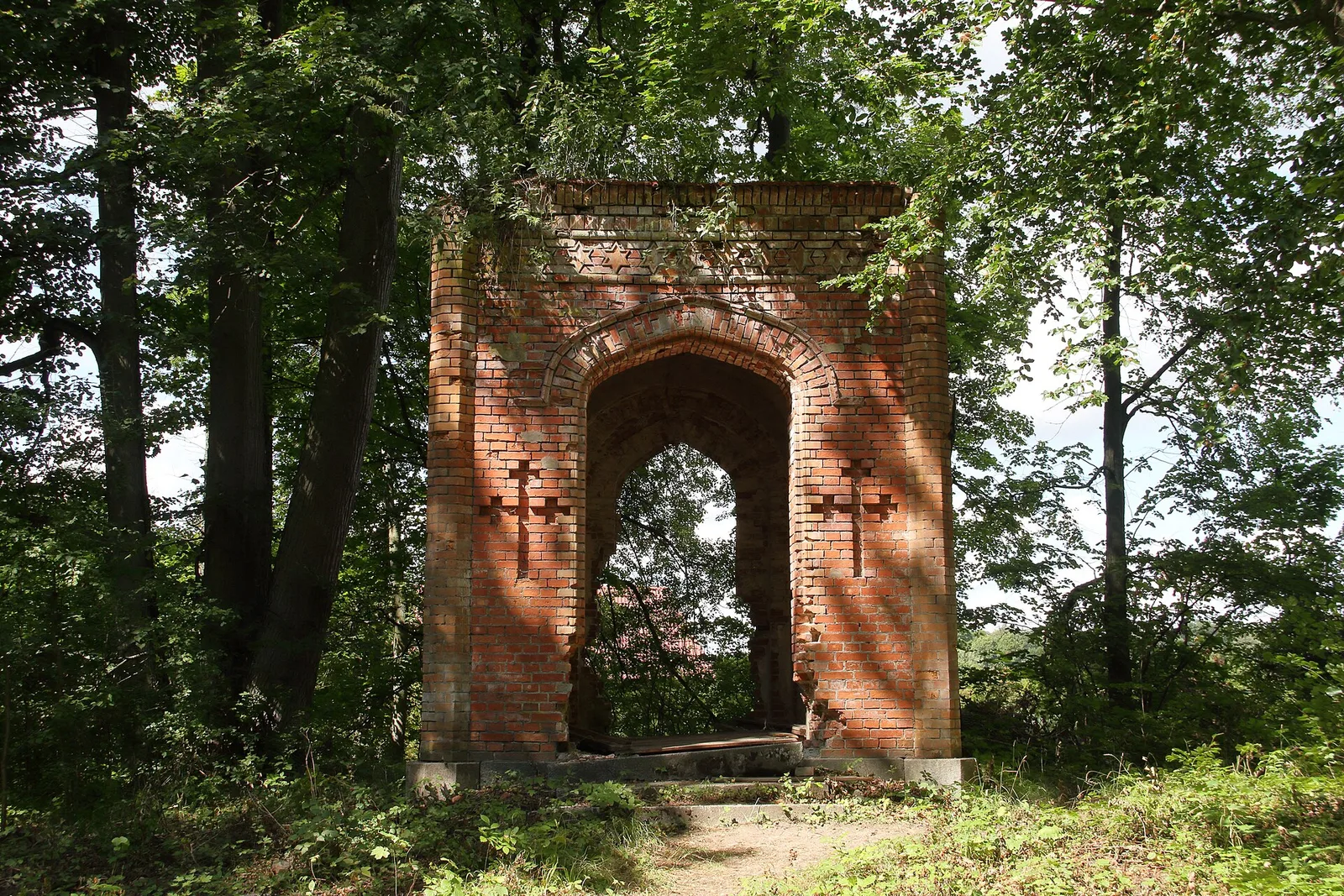 Alte Eichen und verfallene Pavillons prägen das Bild der Allee im Park von Park von Schloss Sztynort im Sommer 2019.