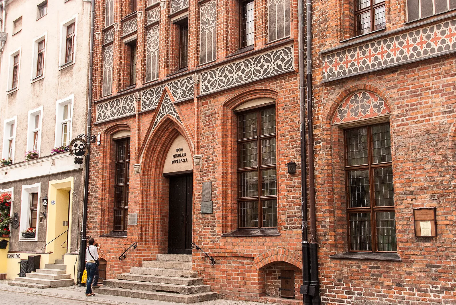 Toruń , ul. Kopernika - zespół dwóch kamienic gotyckich (partie dolne), od lewej: - Kopernika nr 15 ( dawniej 13 ) - gotycka kamienica z oficynami, ok. 1350, obecnie część oddziału